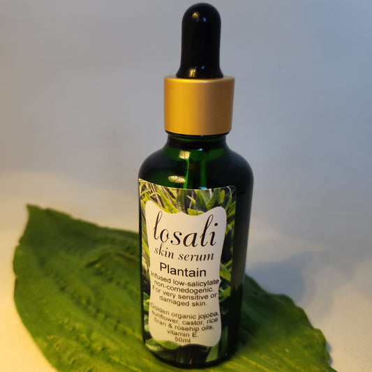 Losali skin serum bottle on a green leaf with a white background